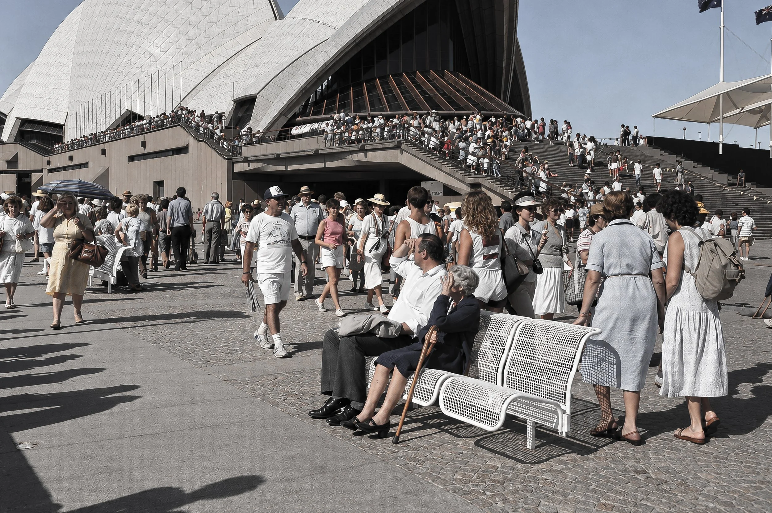 Sydney Harbour and the Opera House Precinct - Visitors gather beside Sydney Harbour with the Opera House rising behind them. The photograph combines architecture, water, tourists and everyday conversation to capture the atmosphere of Sydney's waterfr