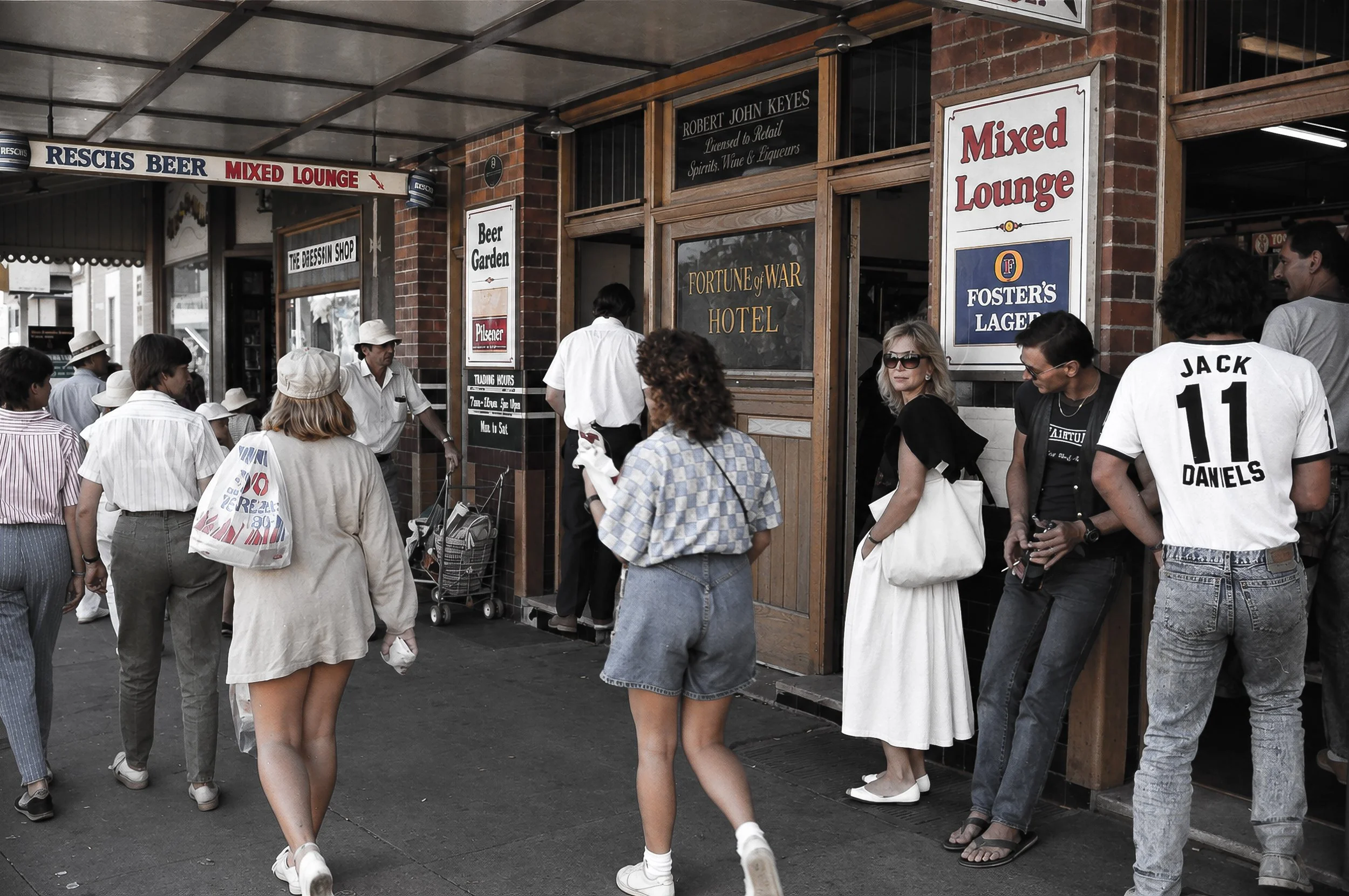 Fortune of War Hotel - Sydney Street Life -People move along the pavement outside the Fortune of War Hotel, surrounded by period shopfronts, brickwork and distinctive Australian beer and hotel signage. The photograph preserves the atmosphere and visu
