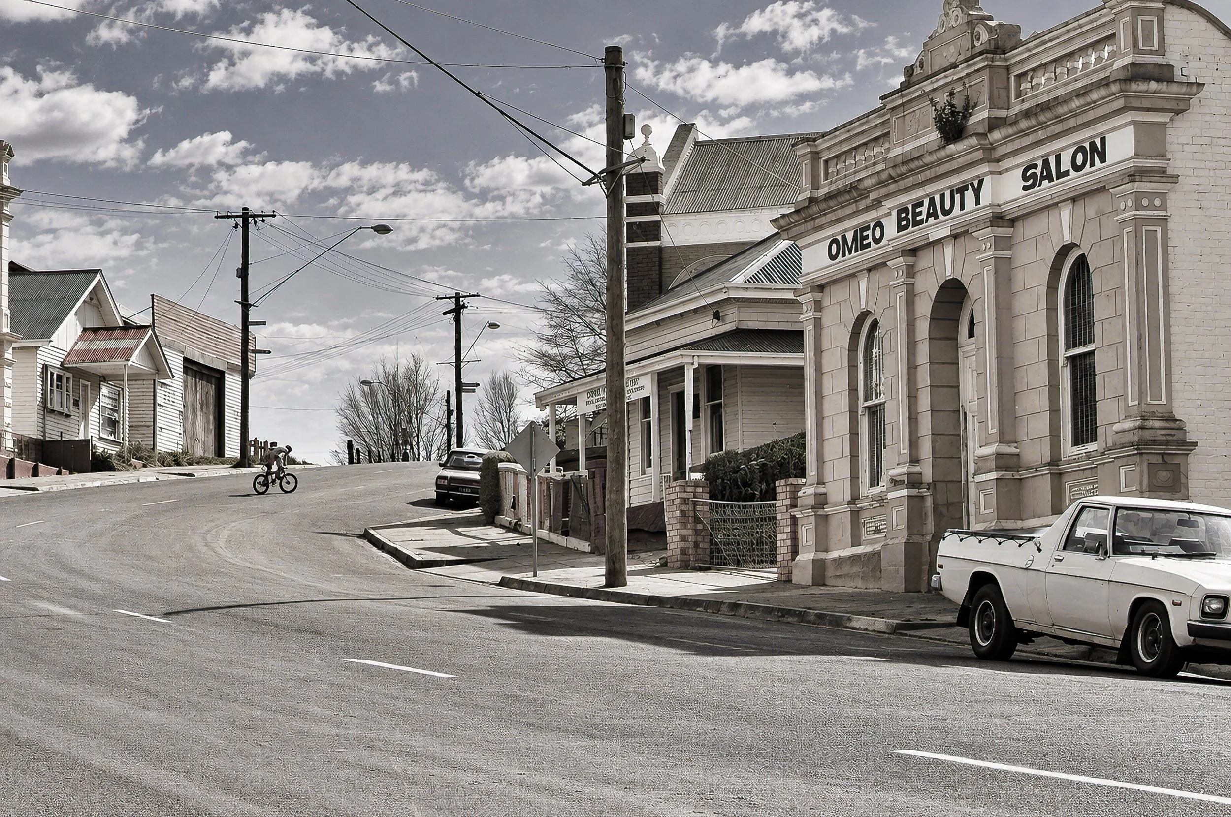 Omeo Main Street - The quiet main street of Omeo, Victoria, photographed during the journey. Historic shopfronts, wide streets and the surrounding mountain country reflect the distinctive character of this High Country settlement in the 1980s.