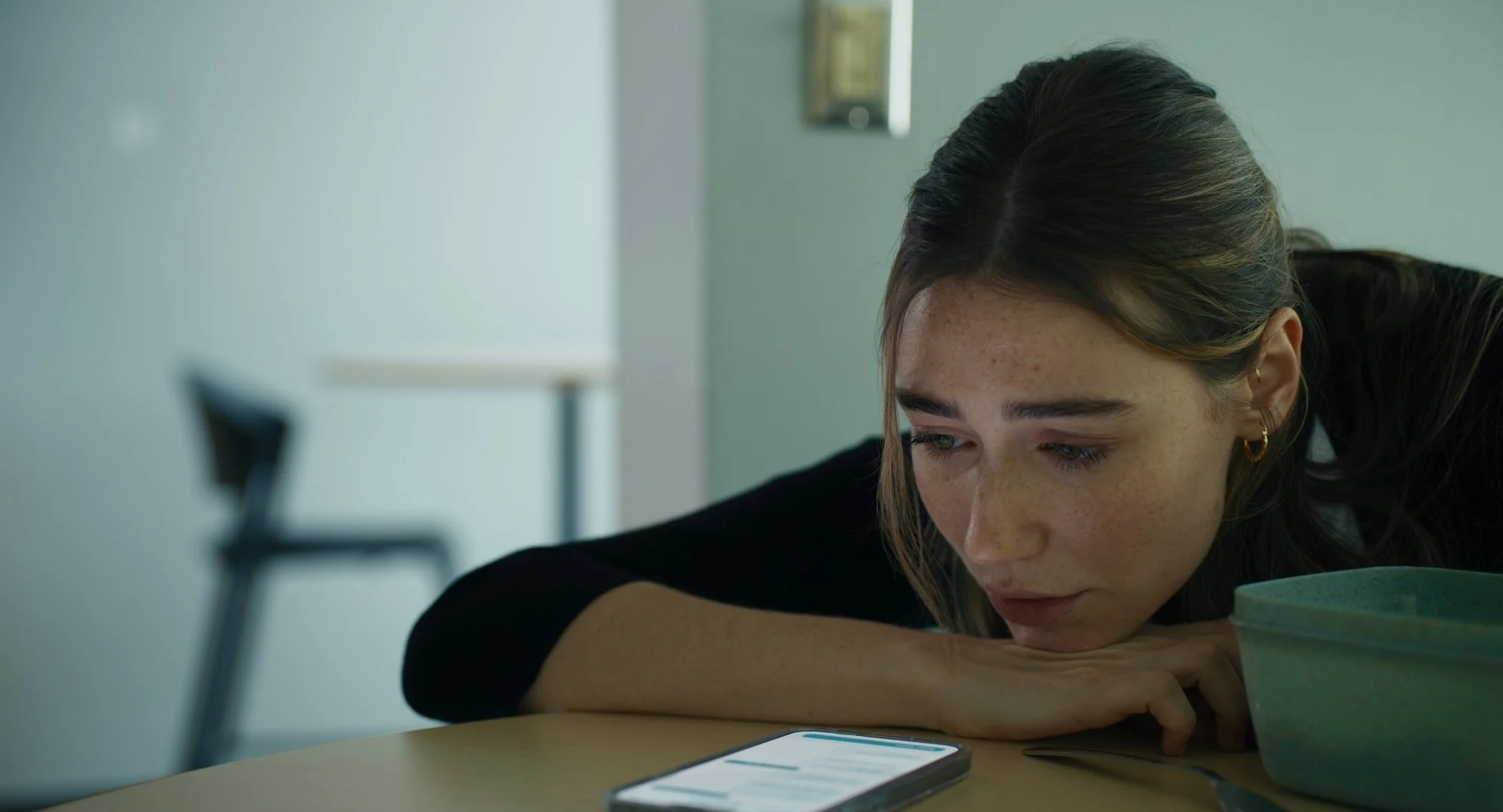 Zoey, played by Kamilla Kowal, looking at her phone in SERENITY