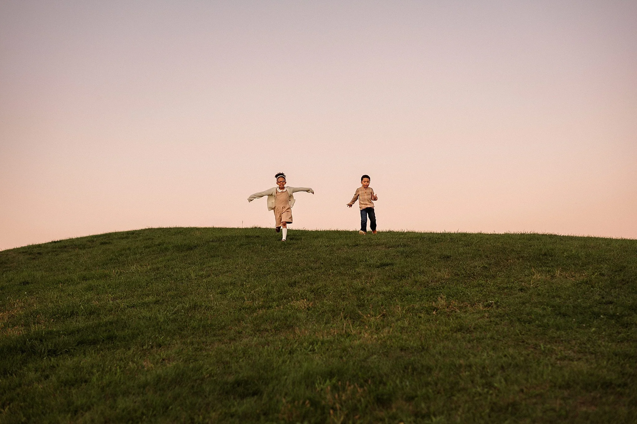 brother and sister running over the hillside joyful family photos