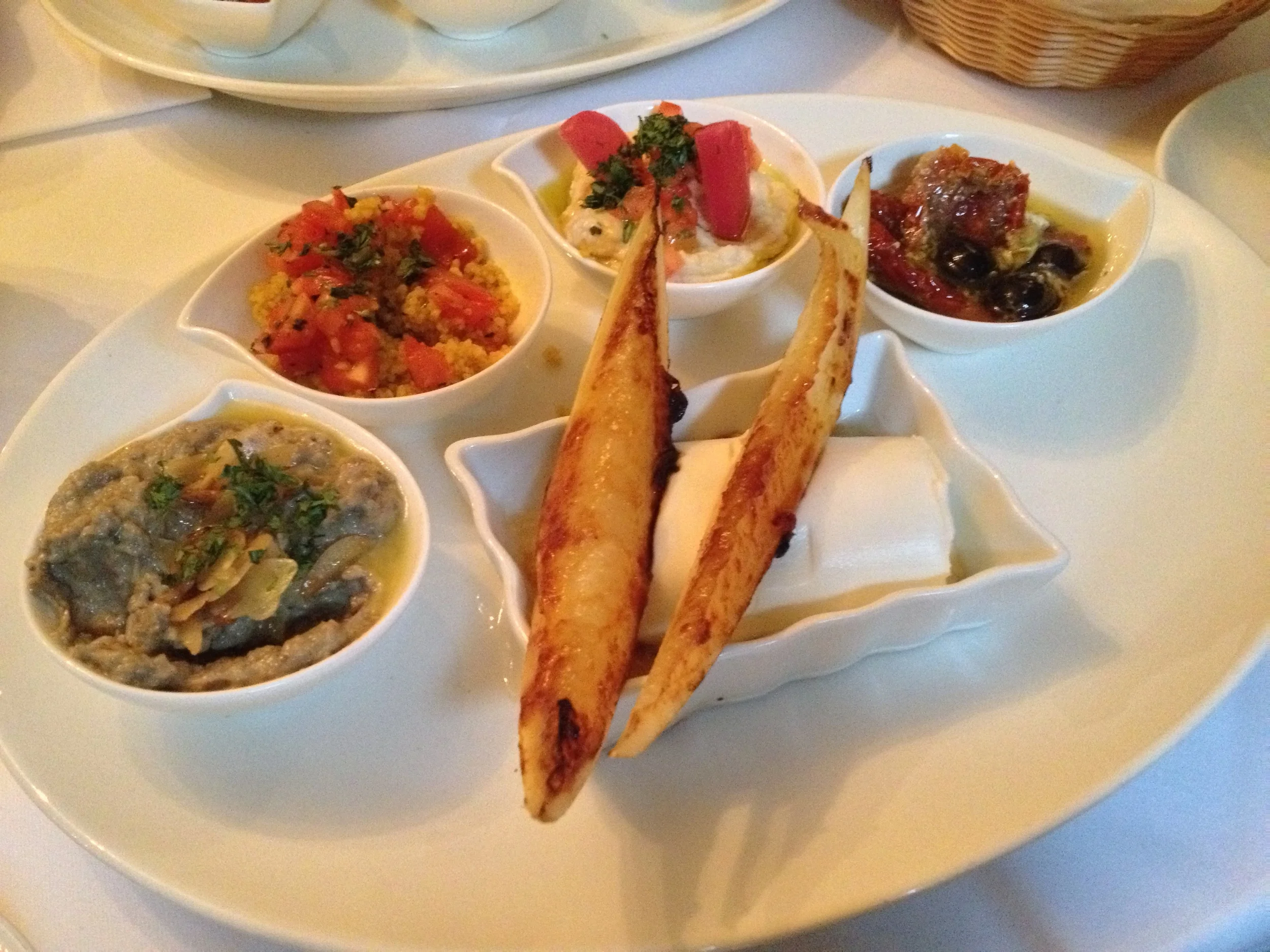 Appetizer platter for two with baba ghanoush, couscous, hummus, olive antipasti, and grilled goat cheese with honey and grilled honey melon