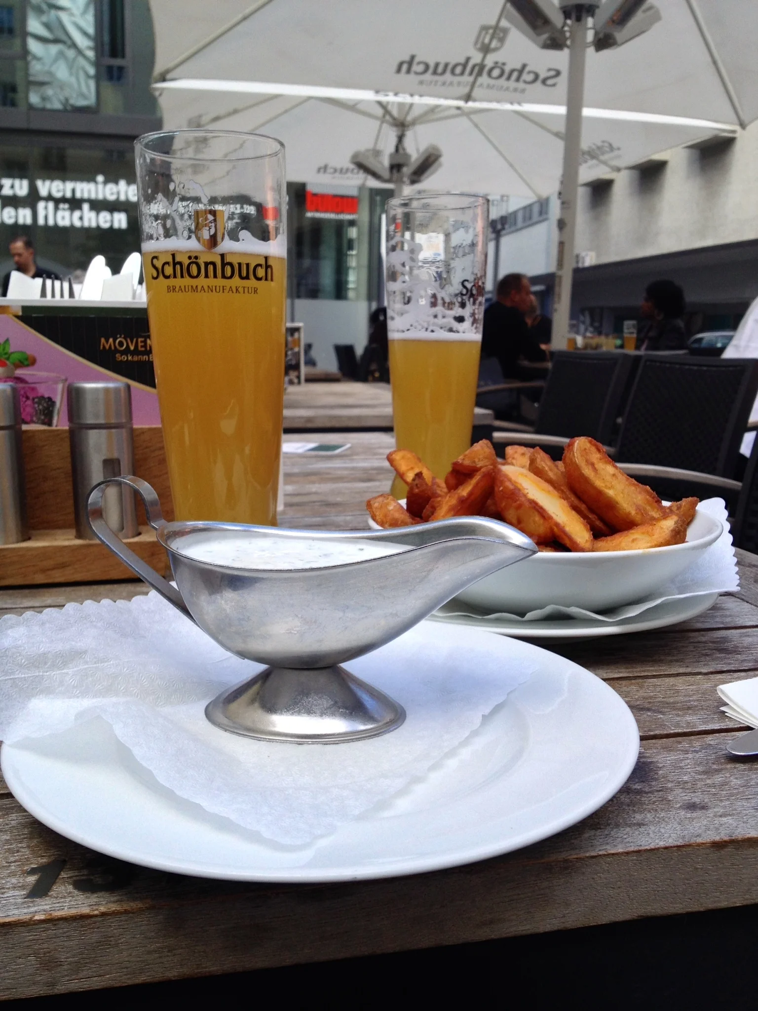 The delicious ofenkartoffel (oven fries) with herb dip and hefeweizen in the background