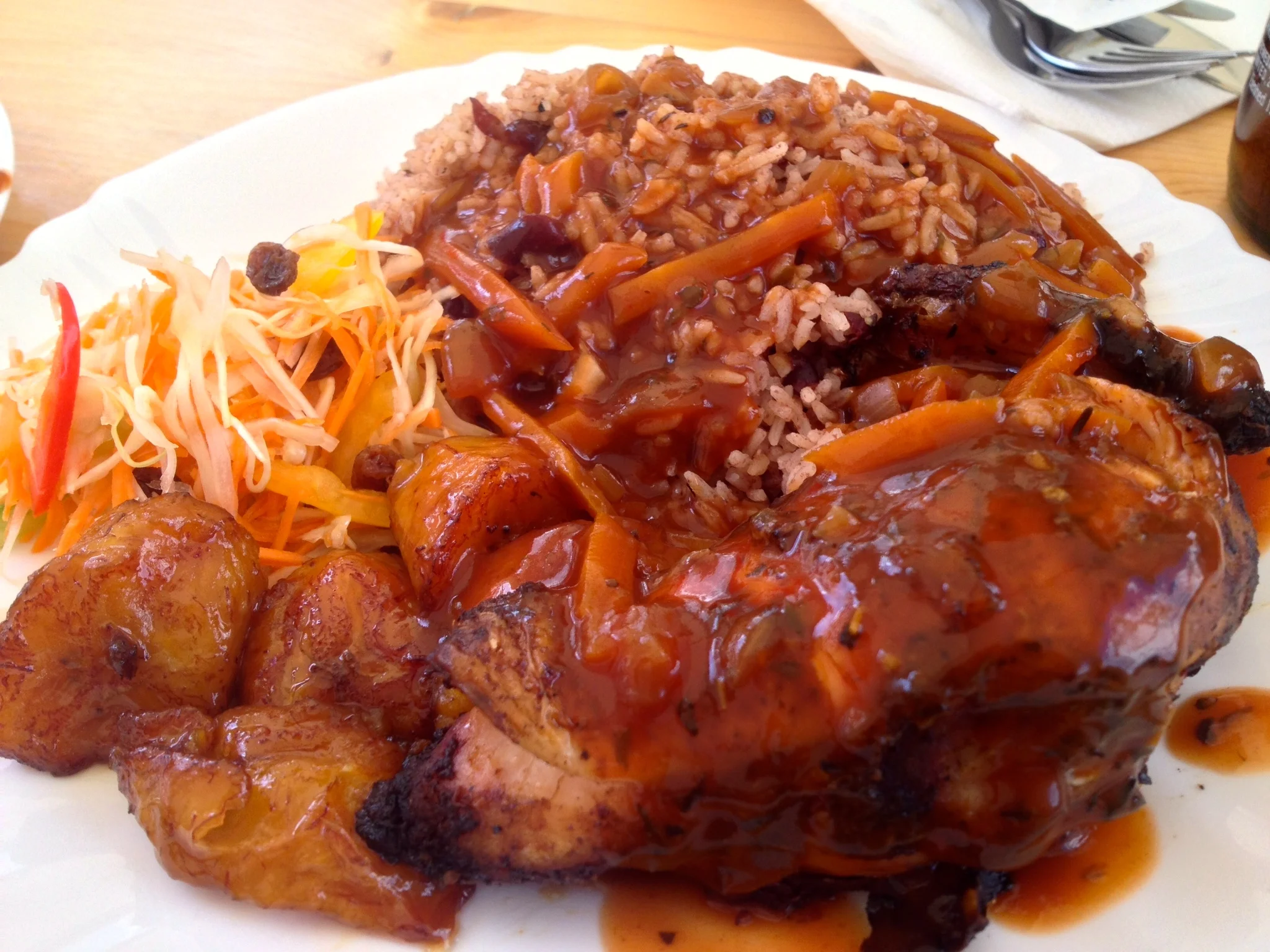 Jerk chicken smothered in a spicy sauce with fried plantains, Caribbean-style salad, and "rice and peas" at Patrick's Stop