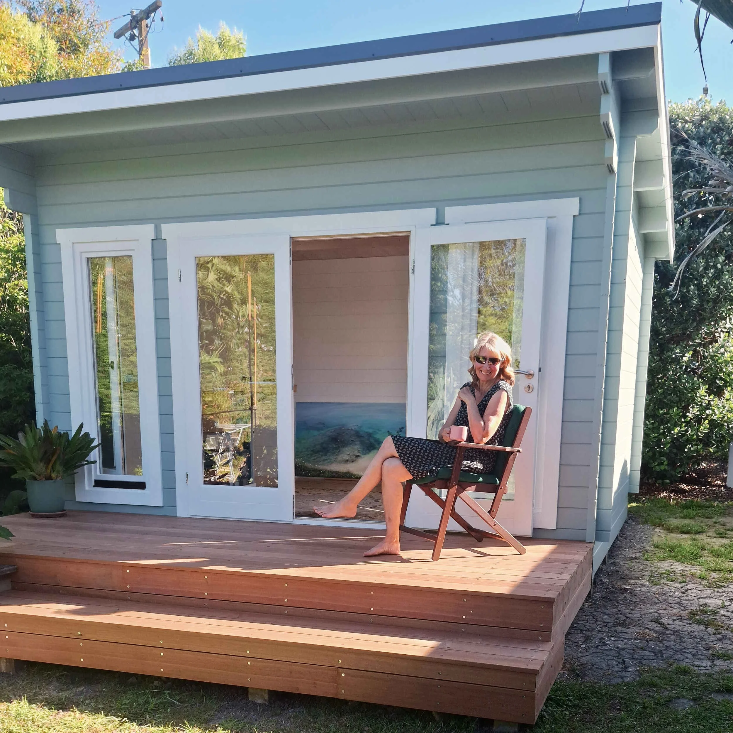 Sonia Fraser Artist relaxing with a cup of tea in her new studio garden