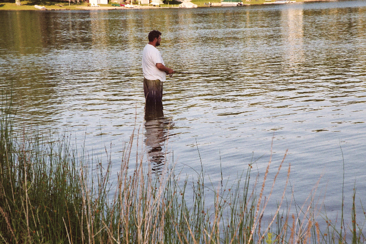 Grassy beach and fisherman at Myers Lake