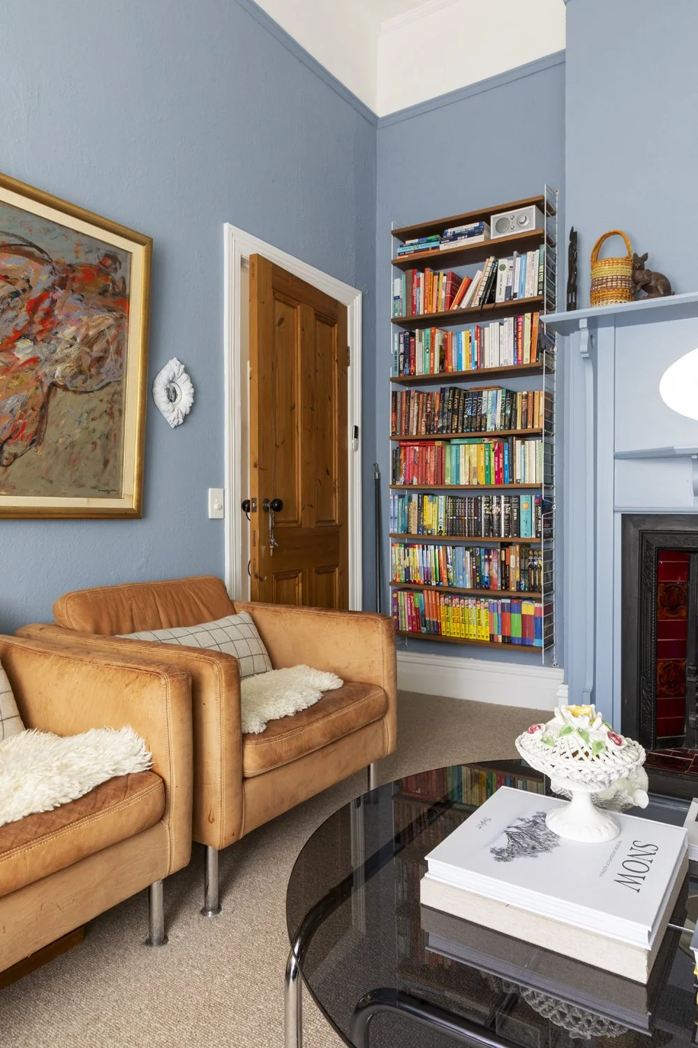 String shelving and tan leather armchairs in traditional sitting room designed by Melbourne interior designer Meredith Lee