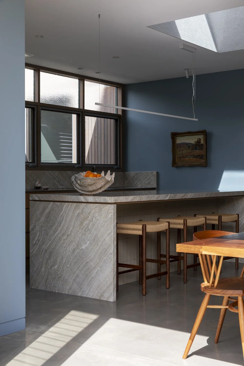 Melbourne interior designers Meredith Lee have used blue painted walls to offset artwork in this family kitchen.