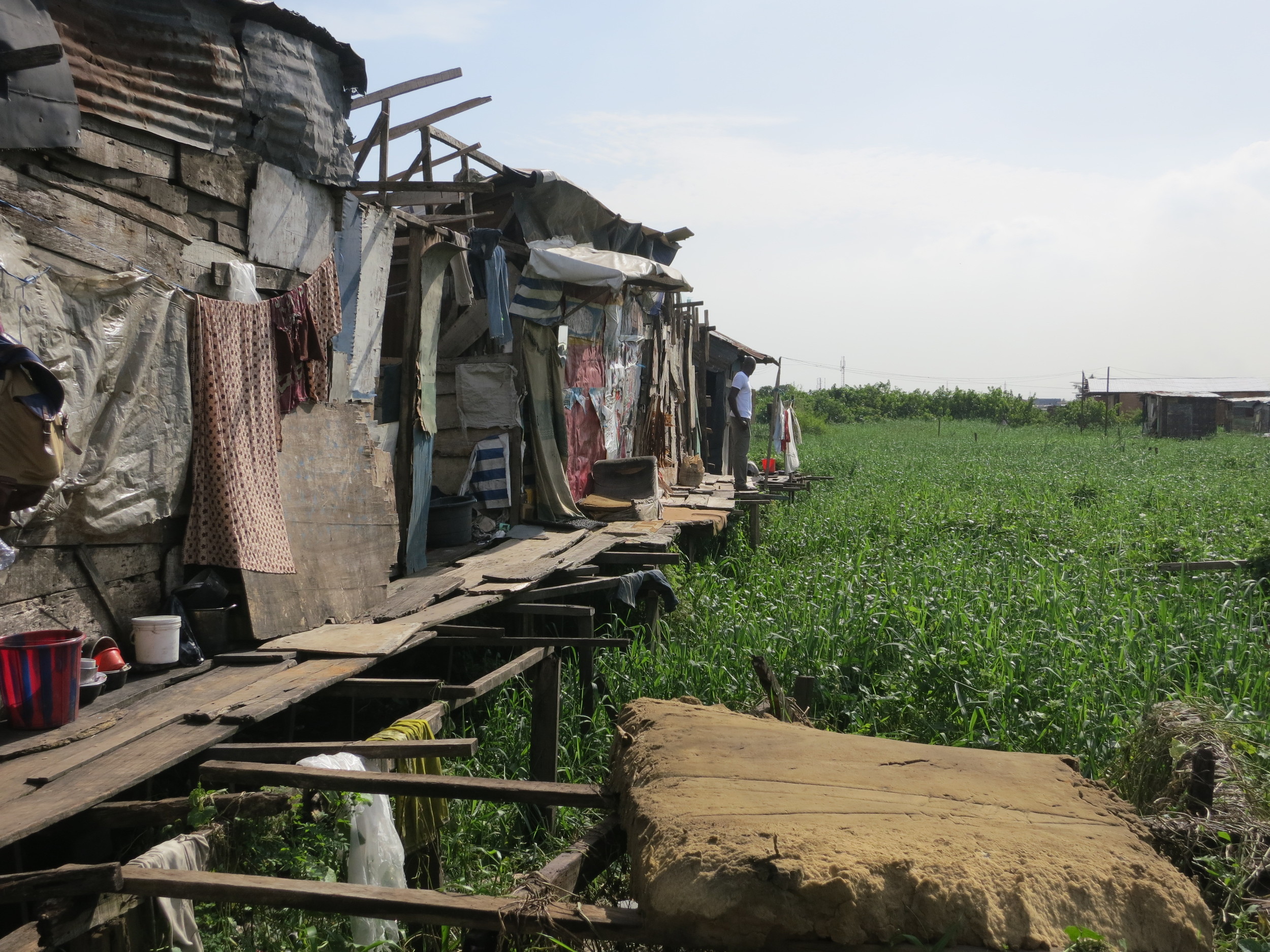 With rapid migration into cities and high birth rates, there is intense pressure on land in urban centers, resulting in innovative building solutions, like shacks on stilts above swamps and drainages.