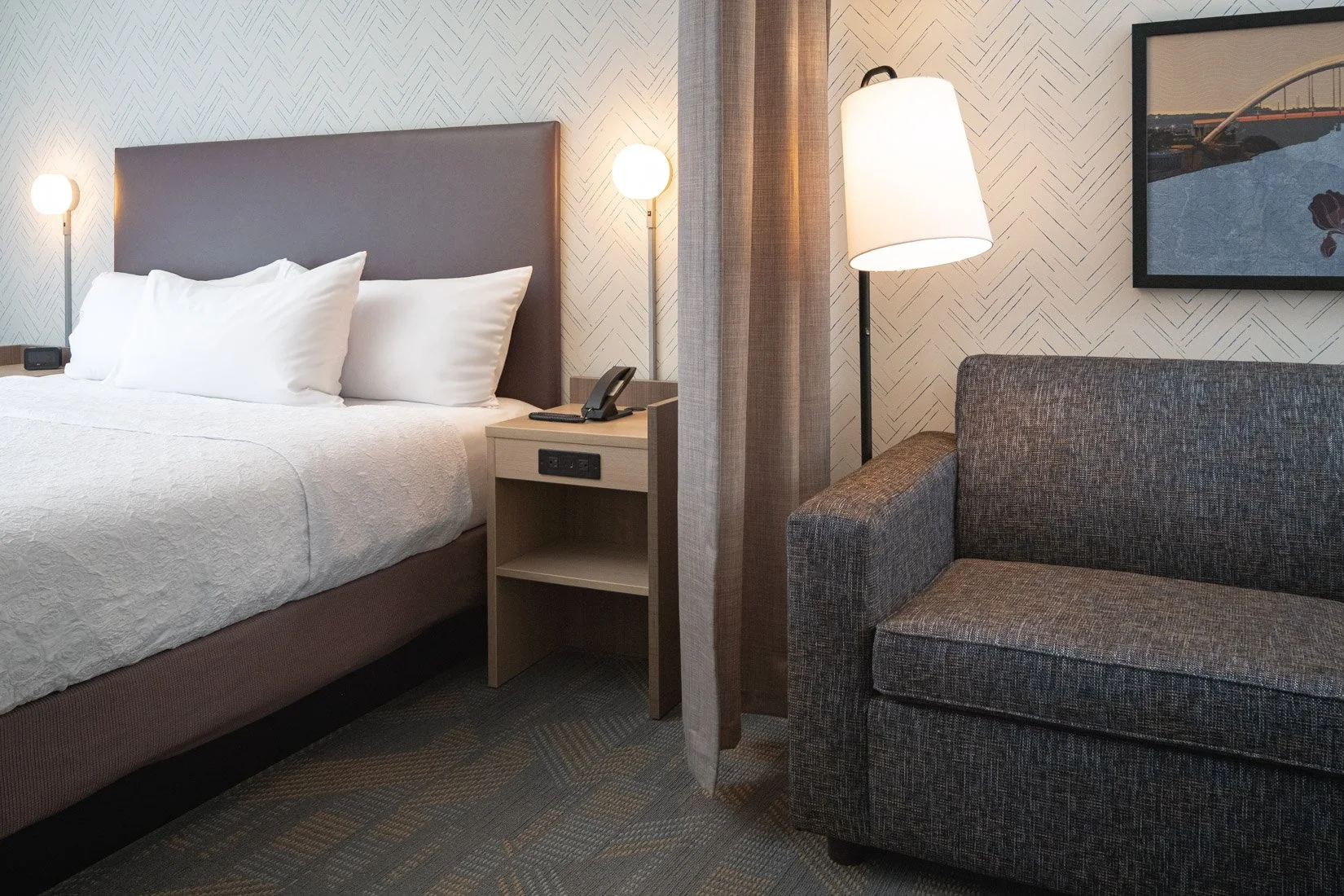  Original Filename: BNALIHT_Home2_roomdivider_4934.jpg File Name: room_divider Caption: Suite room divider Marketing Caption: Room divider provides separation between living and sleeping spaces. Alternate Tag: Sliding divider separating living area a