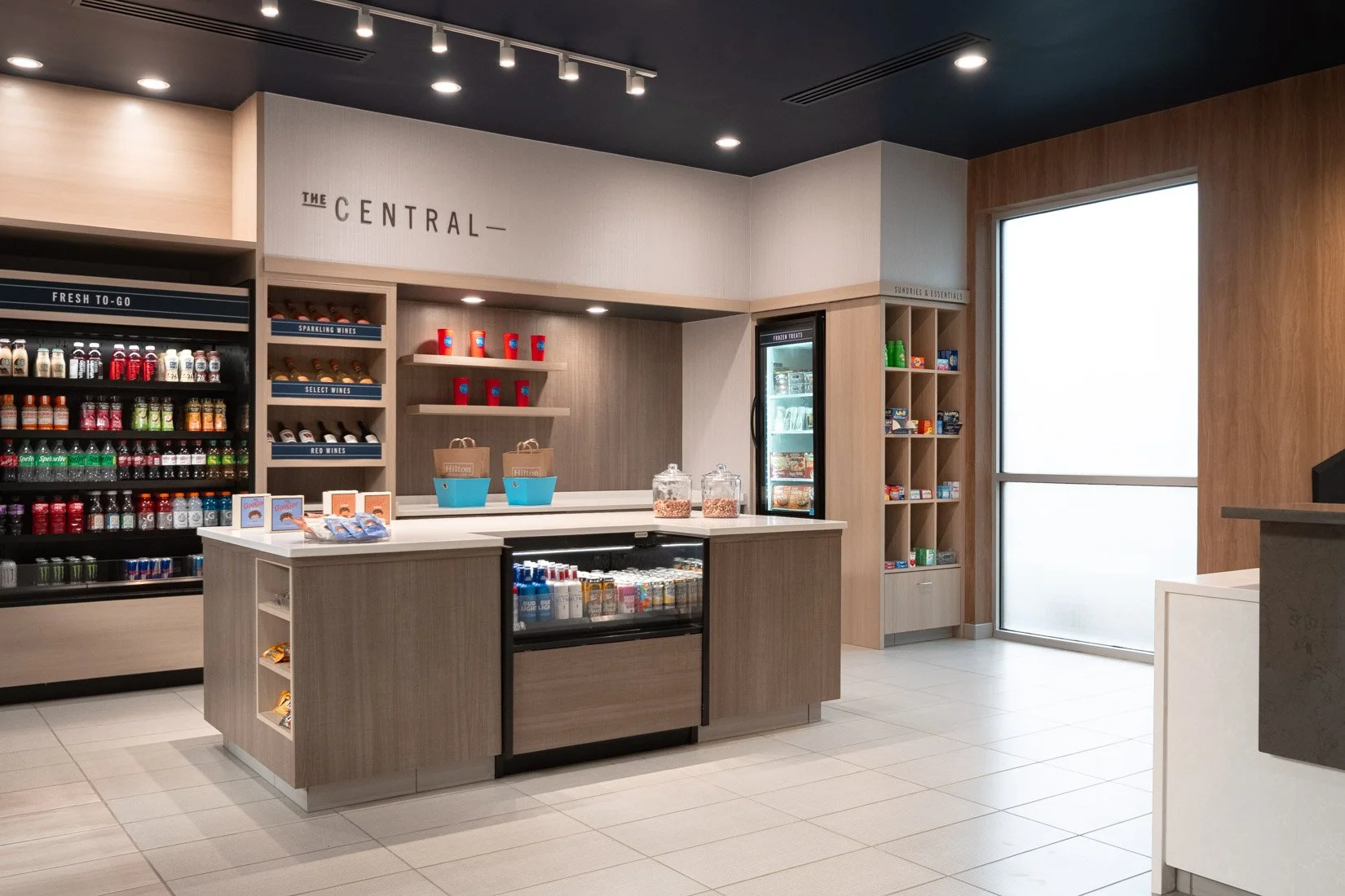  Original Filename: 3906_BNASPRU_TRU_centralmarket.jpg File Name: Tru-Central-Market.jpg Caption: Central Market snack and retail area Marketing Caption: Central Market at Tru by Hilton Spring Hill offering snacks, drinks, and travel essentials. Alte