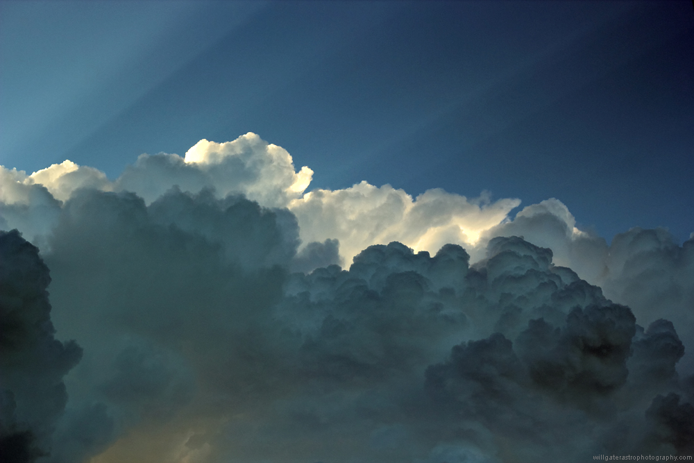 Thunder clouds backlit by the setting Sun with crepuscular rays