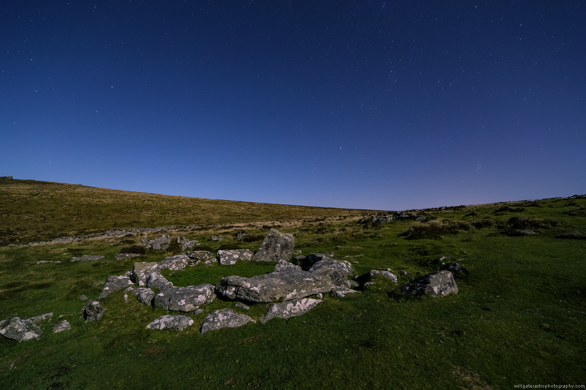 Stars over a moon-lit Bronze Age hut circle at Grimspound, Dartmoor
