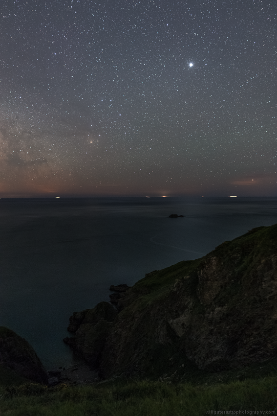 The faint glitter paths of Jupiter (top right) & the bright star Antares (centre left) on the English Channel from the south Devon coast. Faint airglow is also visible above the horizon at right.