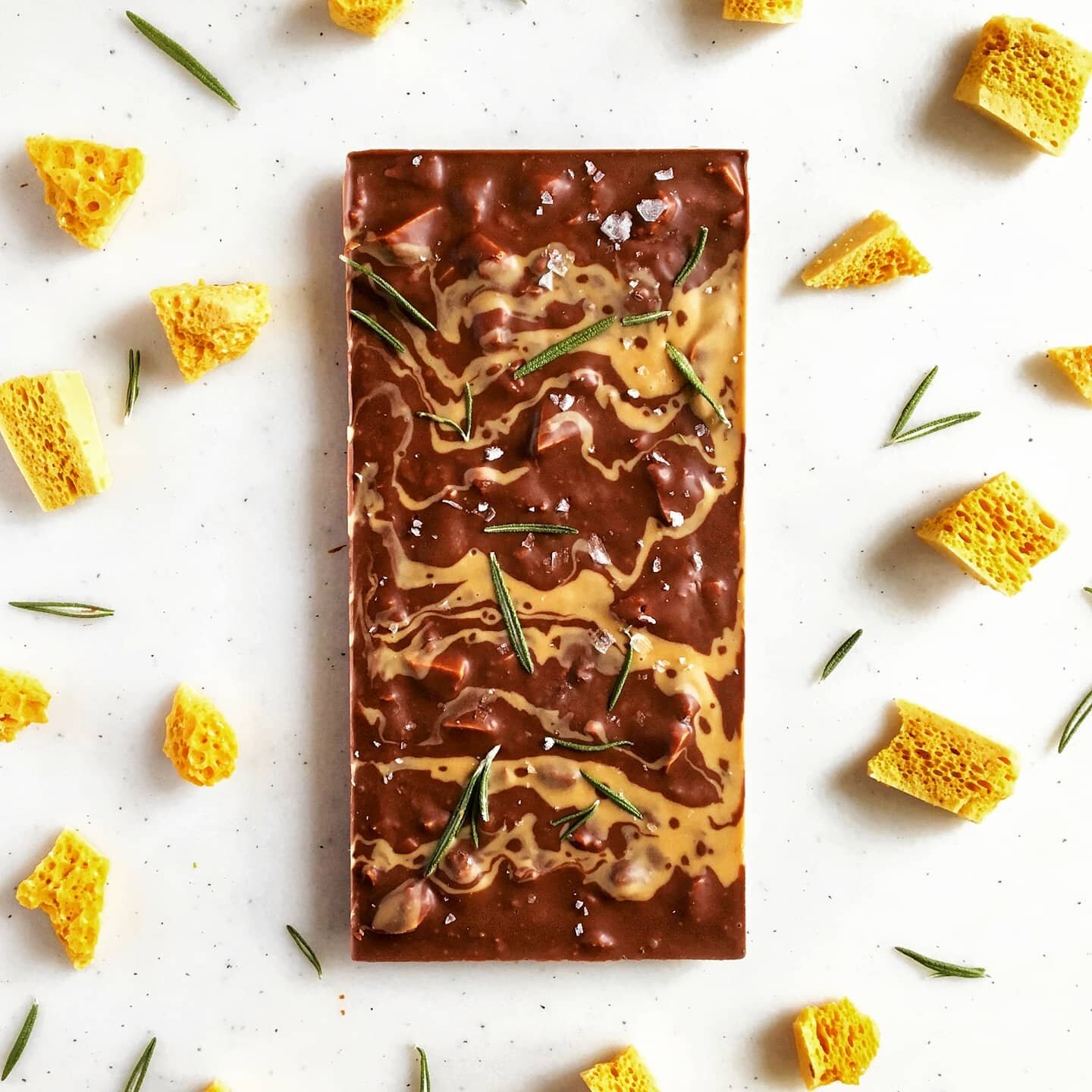 46% milk chocolate (darker than the typical) infused with fresh rosemary then mixed with crushed Ontario buckwheat honey sponge toffee.  Finished with swirls of roasted white chocolate and @maldonsalt sea salt.  Can't best that combo. Grab one now at