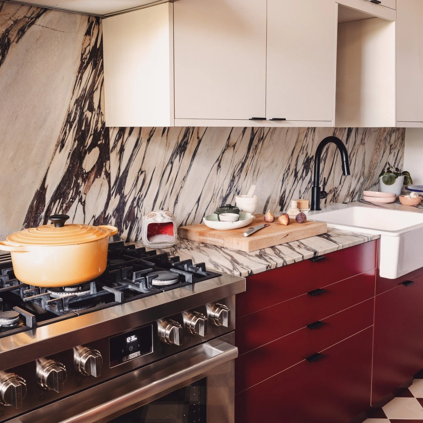 When I updated this kitchen in a historic Hyde Park home, I wanted it to feel as fearless and full of life as my client. The @plykea burgundy cabinetry and @zia_tile checkerboard floors in Canyon and Bone draw directly from the original muse: the to-