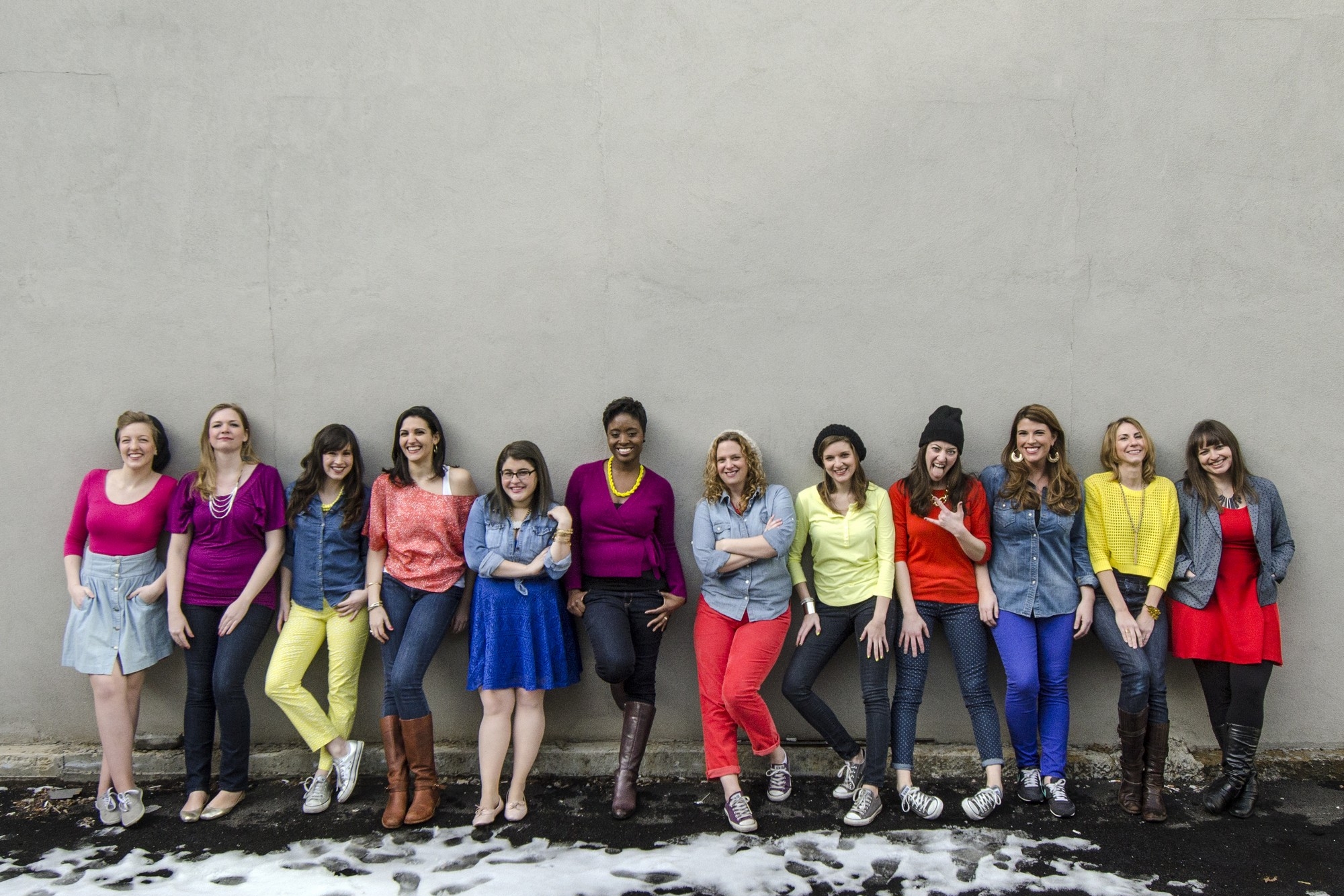 Treble NYC in colorful outfits against an NYC wall