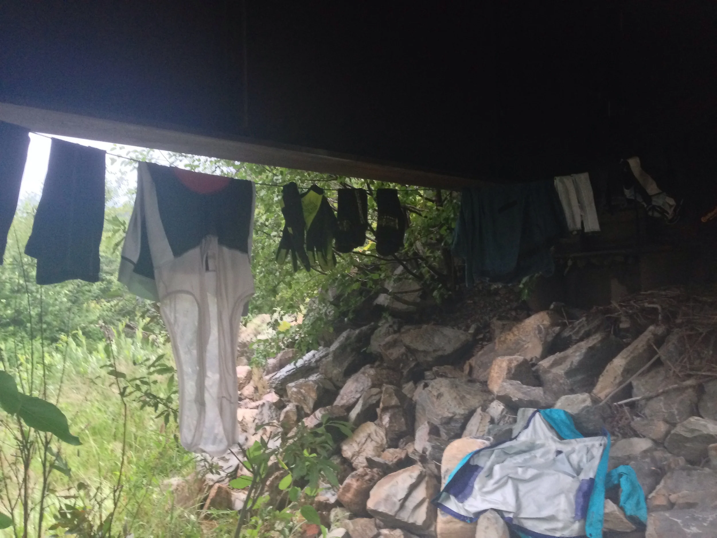Hanging clothes and cooking dinner under a bridge during a long rain shower.