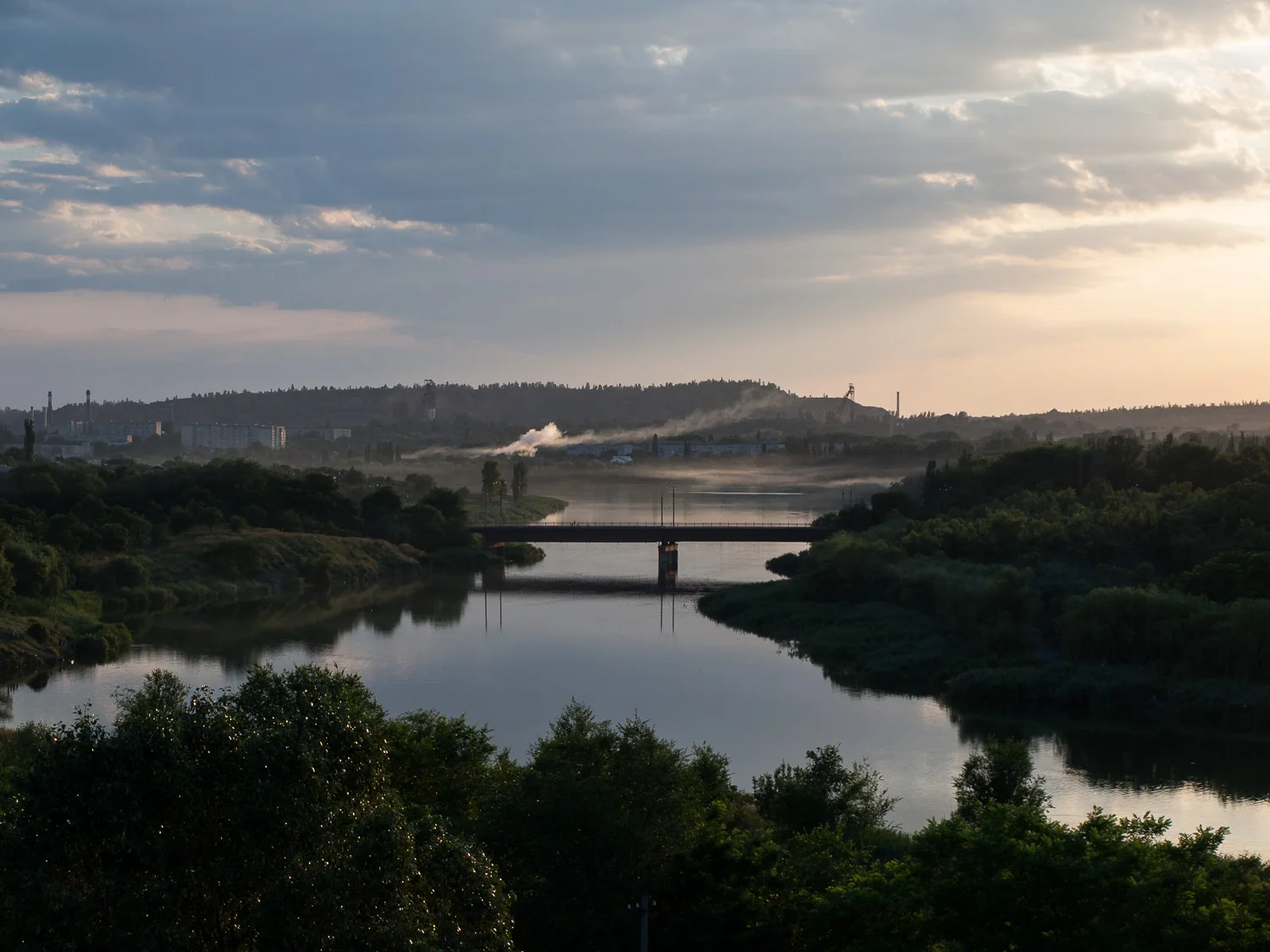 A view over the Inhulets river at Kryvyi Rih. Headframes for the city’s numerous iron ore mines are visible in the background.