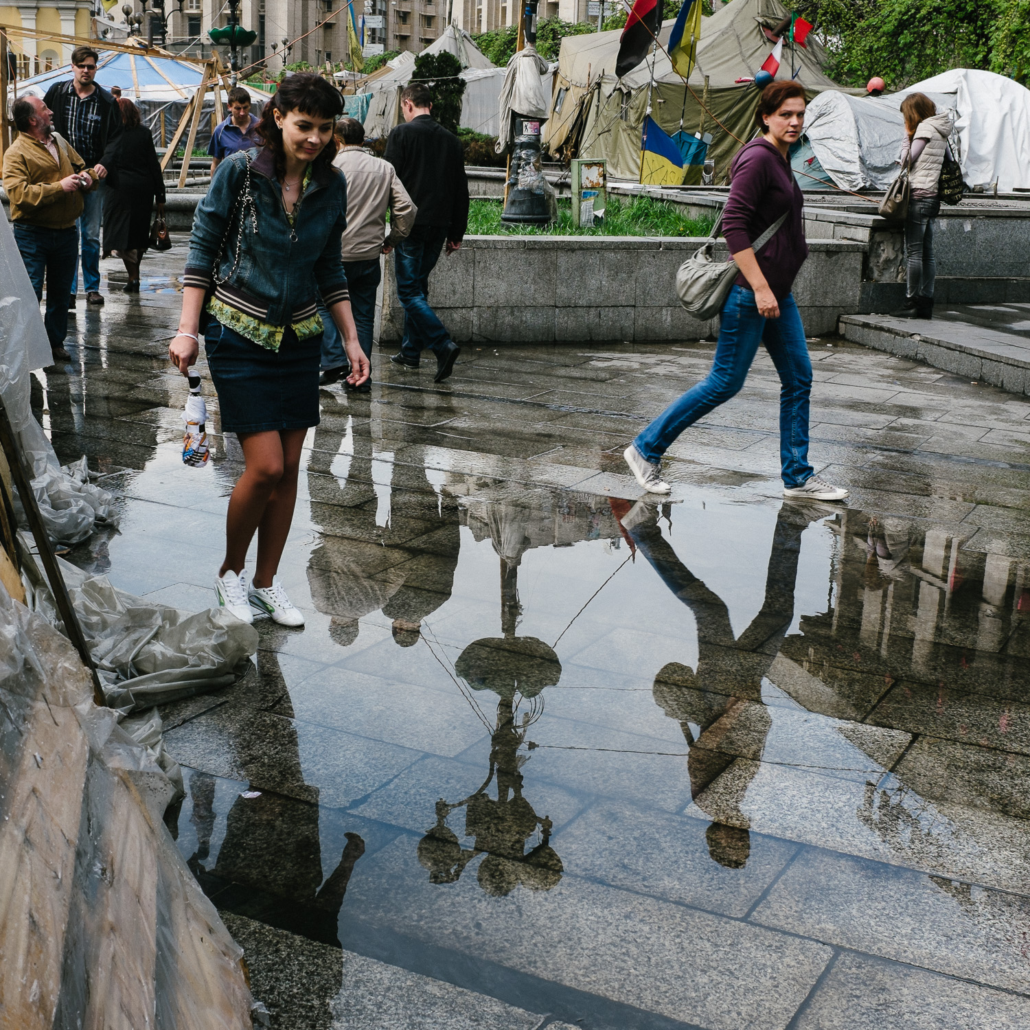  People step around puddles of water after a rain shower on Kyiv's Independence Square, April 2014. 