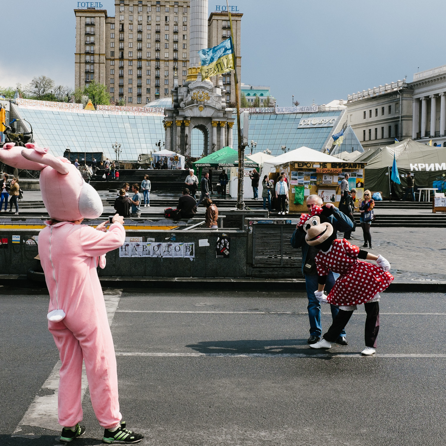  A tourist poses with workers dressed as cartoon characters on Kyiv's Independence Square, April 2014. 