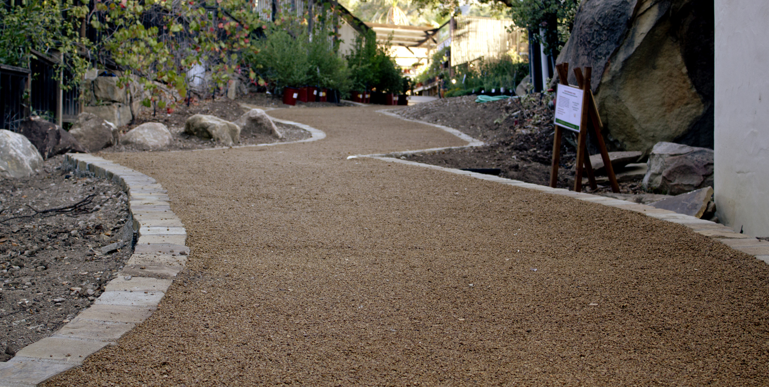 Strolling pathway leads down a hill to patio. 