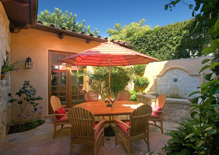 Maximizing a small patio with the soothing sounds a fountain mixed with lush plantings and enough seating for an intimate gathering 