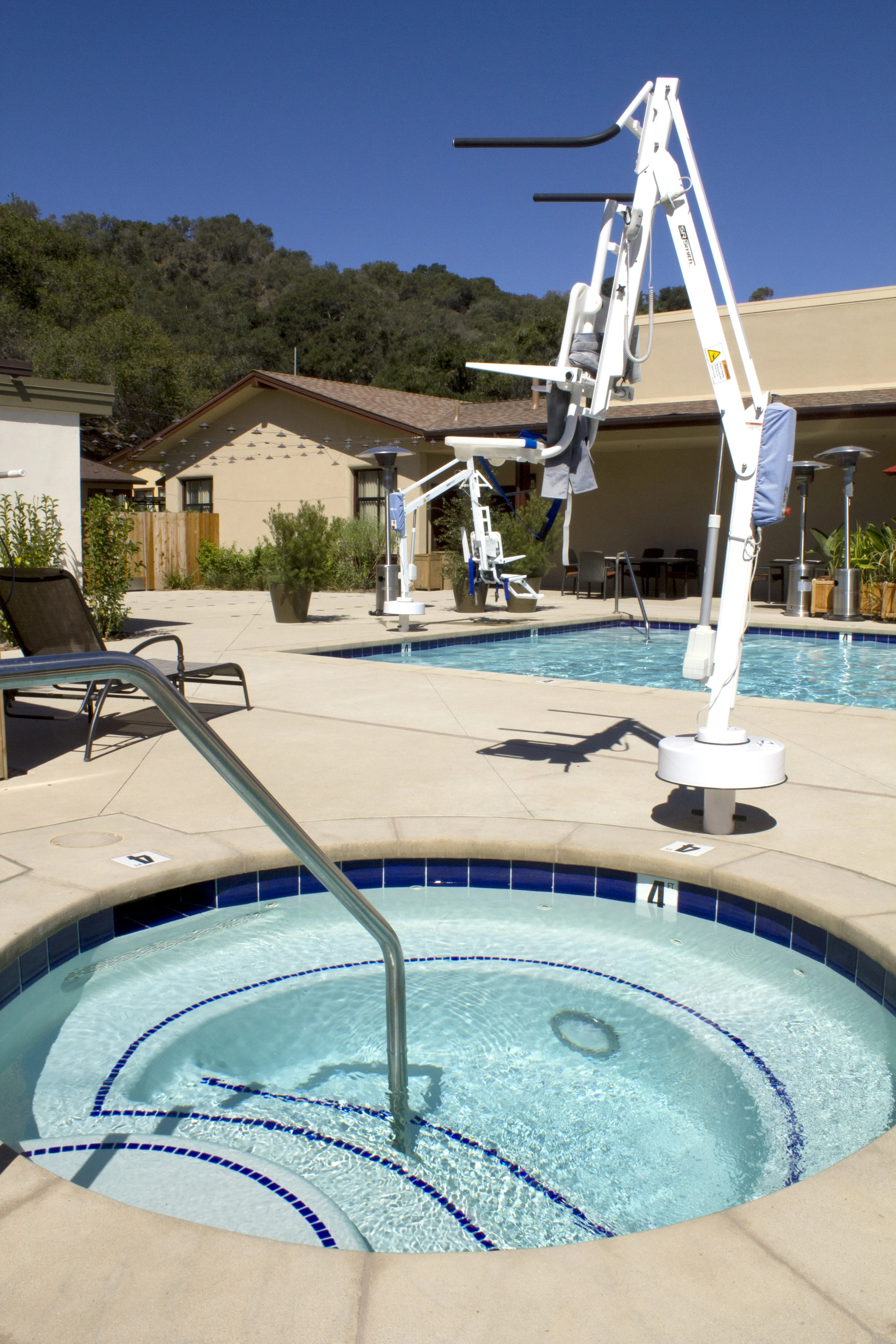 Pool and spa for retirement community, rich deep blue tiles on steps and spa bench create contrast clearly defined ledge boundaries while maintaining pleasant aesthetic.