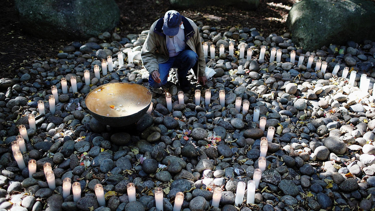 A man lights a candle in the National Aids Memorial grove in San Fransisco.
