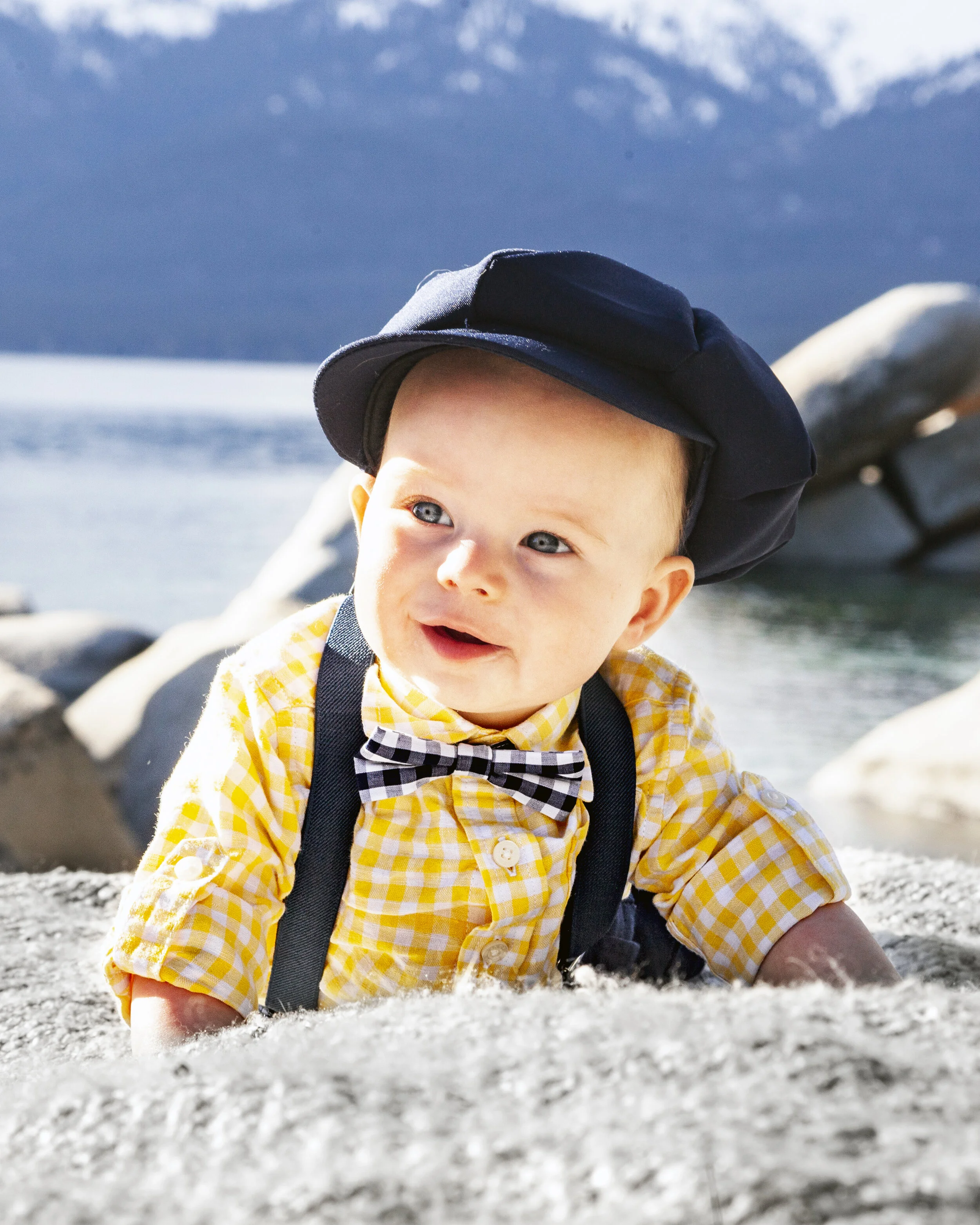 Infant laughing in an outdoor portrait session in Lake Tahoe with natural scenery.