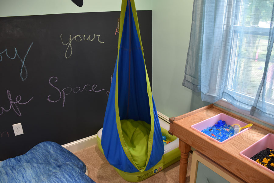 Hanging Joki swing to help keep the kids calm -- it can rotate towards the TV or towards the less-stimulating corner with ball pit