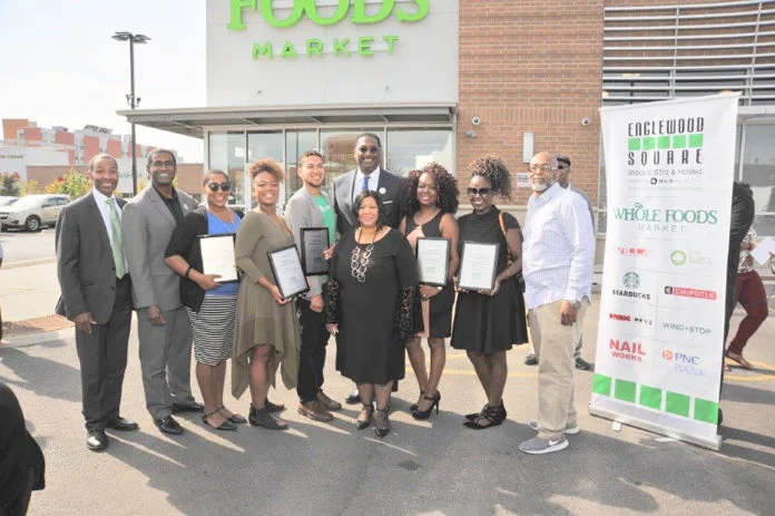 ENGLEWOOD SQUARE CELEBRATES first year–Leon Walker, DL3 Realty managing partner and developer of Englewood Square, hosted a one-year anniversary celebration for the shopping center located at 63rd and Halsted streets. Mayor Rahm Emanuel was in attendance with other dignitaries, recording artist Gene “The Duke of Earl” Chandler, and internationally-renowned visual artist Samuel Akainyah, who unveiled a new painting. PNC Bank, which is soon to open at Englewood Square, sponsored awards presented for excellence in community service and entrepreneurship. Celebrating, left to right, are: Thurman “Tony” Smith, PNC Bank; Derrick Young, CBS2 Chicago; Asiaha Butler, president of R.A.G.E. (Residents Association of Greater Englewood); Chrishon Lampley of Love Cork Screw; Jordan Buckner of Tea Squares; 16th ward Ald. Toni Foulkes (in front); Walker (in back); Iris Patterson of Iris Botanicals; and Edward and Jennifer Alexander of Island Indulgences.