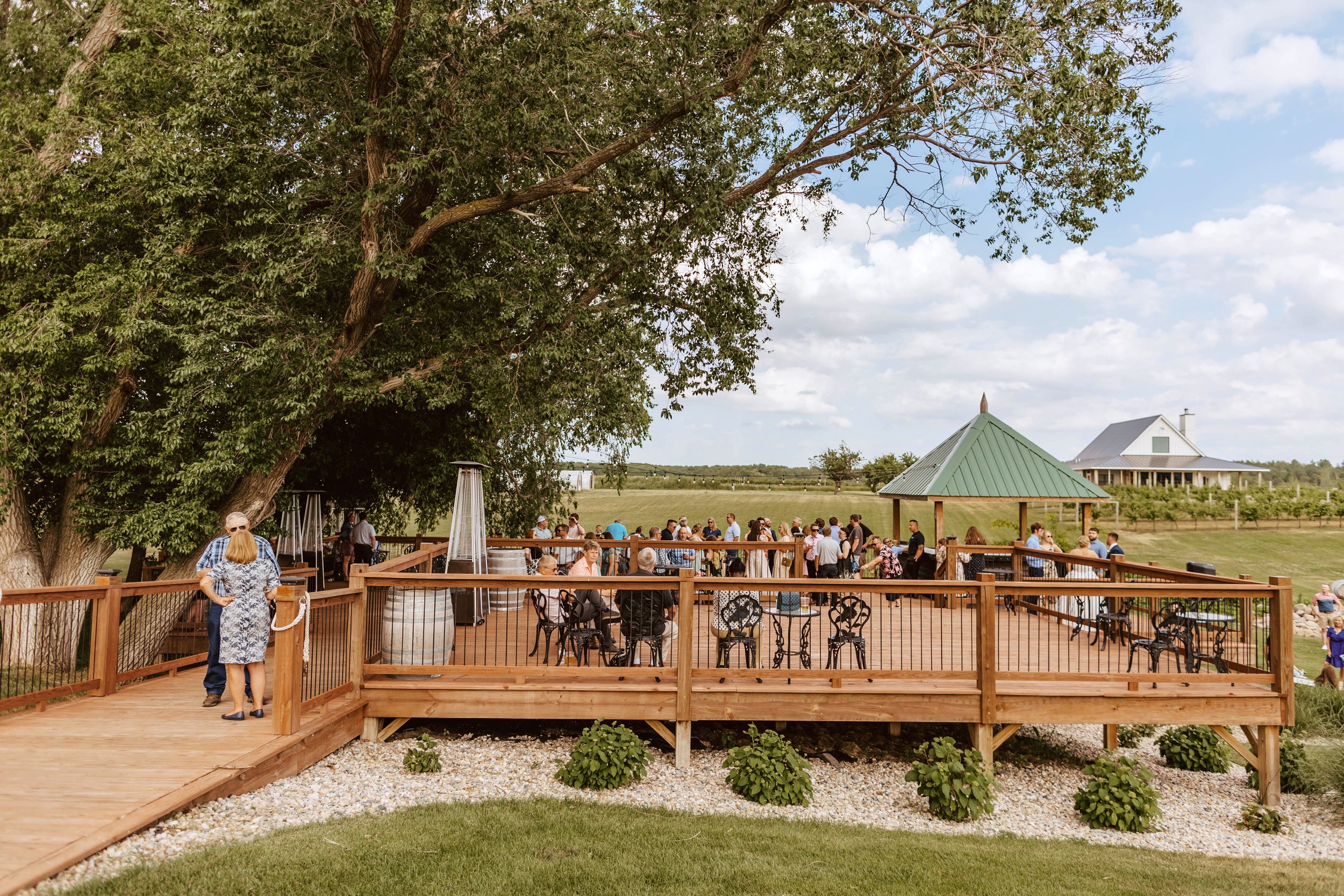 Three-tier, outdoor social hour deck overlooking a vineyard.