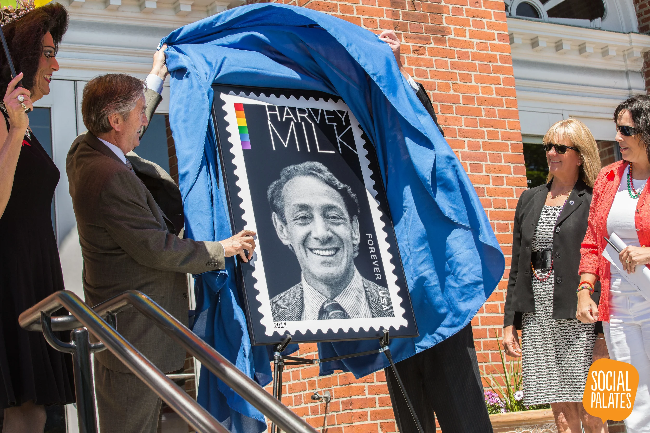 Congressman John Tierney and Salem Postmaster Mark Howell unveil the Harvey Milk Forever Stamp alongside Mayor Kim Driscoll, State Senator Joan Lovely, the Queen of Salem Gigi Gill, and other LGBT activists and supporters on June 1, 2014.