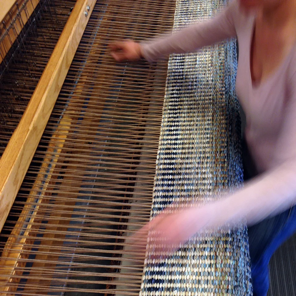 Weaver Michelle speedily works away on the recent Columns Ink rug.