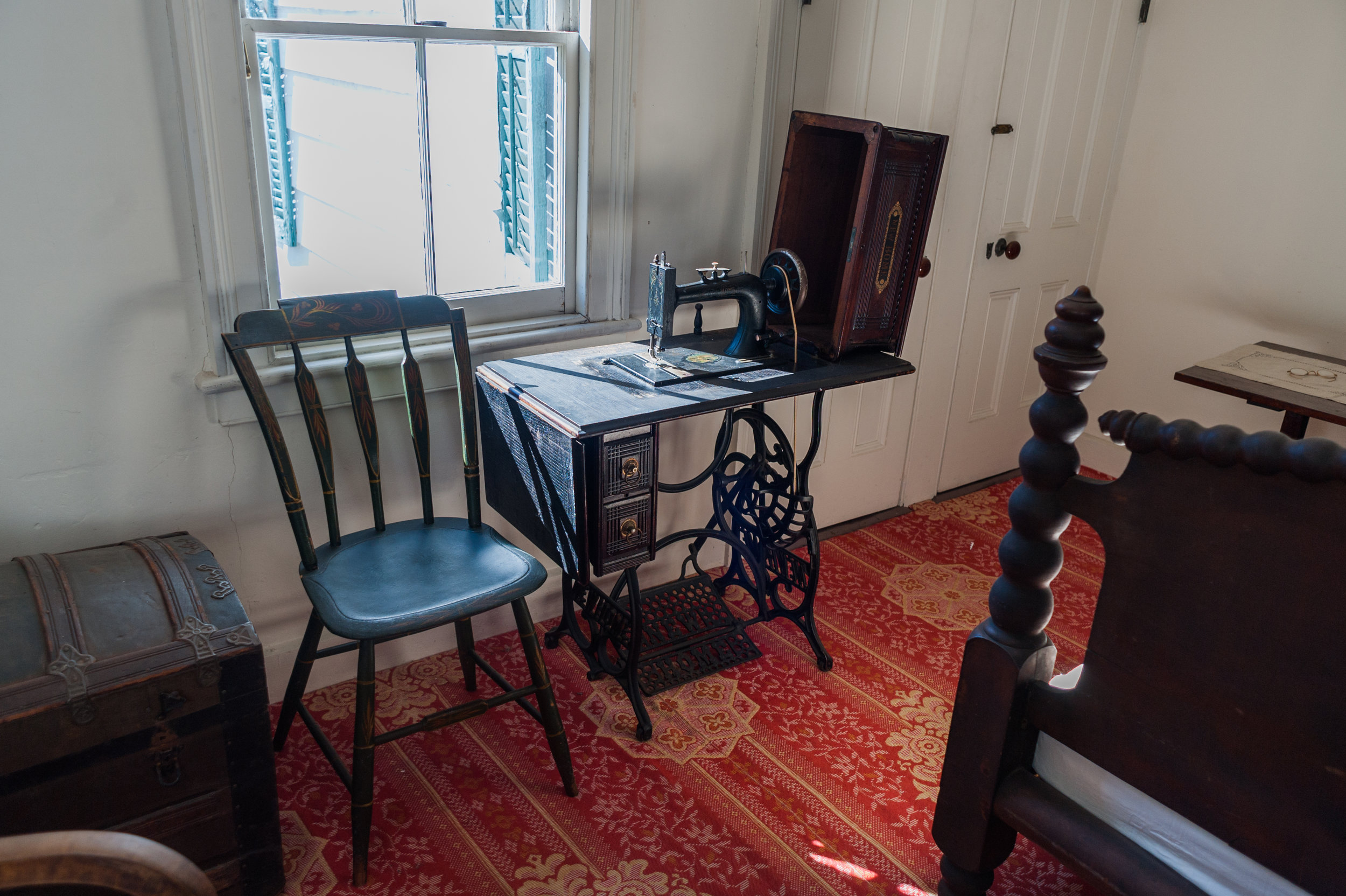 A later model sewing machine was placed in the master bedroom. The pattern of the carpet is Linderwald. It was copied from the 1856 James Van Buren House in Kinderhook, New York. (Copy)