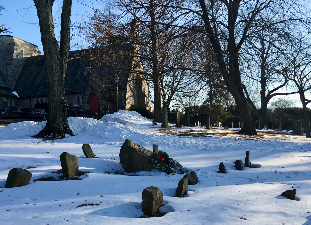 A plaque, wreathed for Christmas in St. James the Less Cemetery in Scarsdale, commemorates the unmarked graves of fugitive slaves.