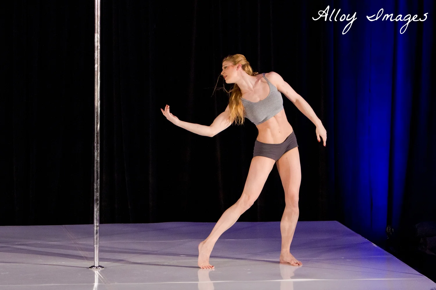 Shaina Cruea performing on stage her signature ContemPOLEary dance routine.
