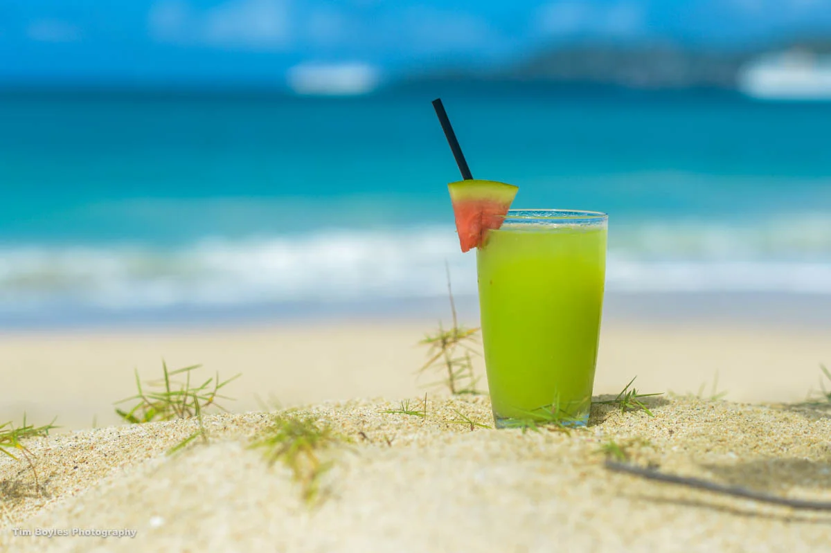 A watermelon-flavored drink sits on the beach in Grenada.
