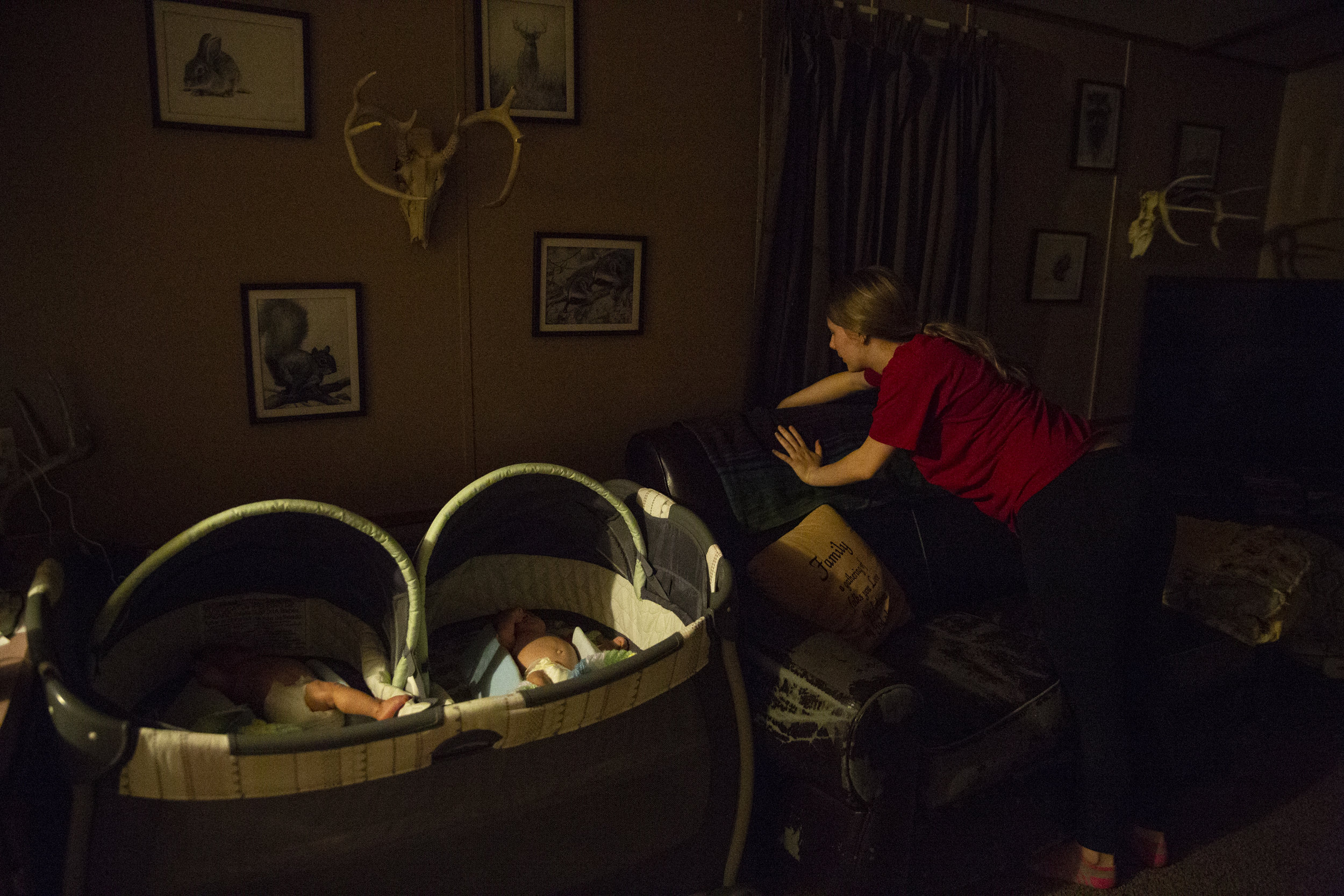  First-time mother April Riley, 19, cleans up at night after her three-month-old twins, Eli and Evan, fall asleep. 