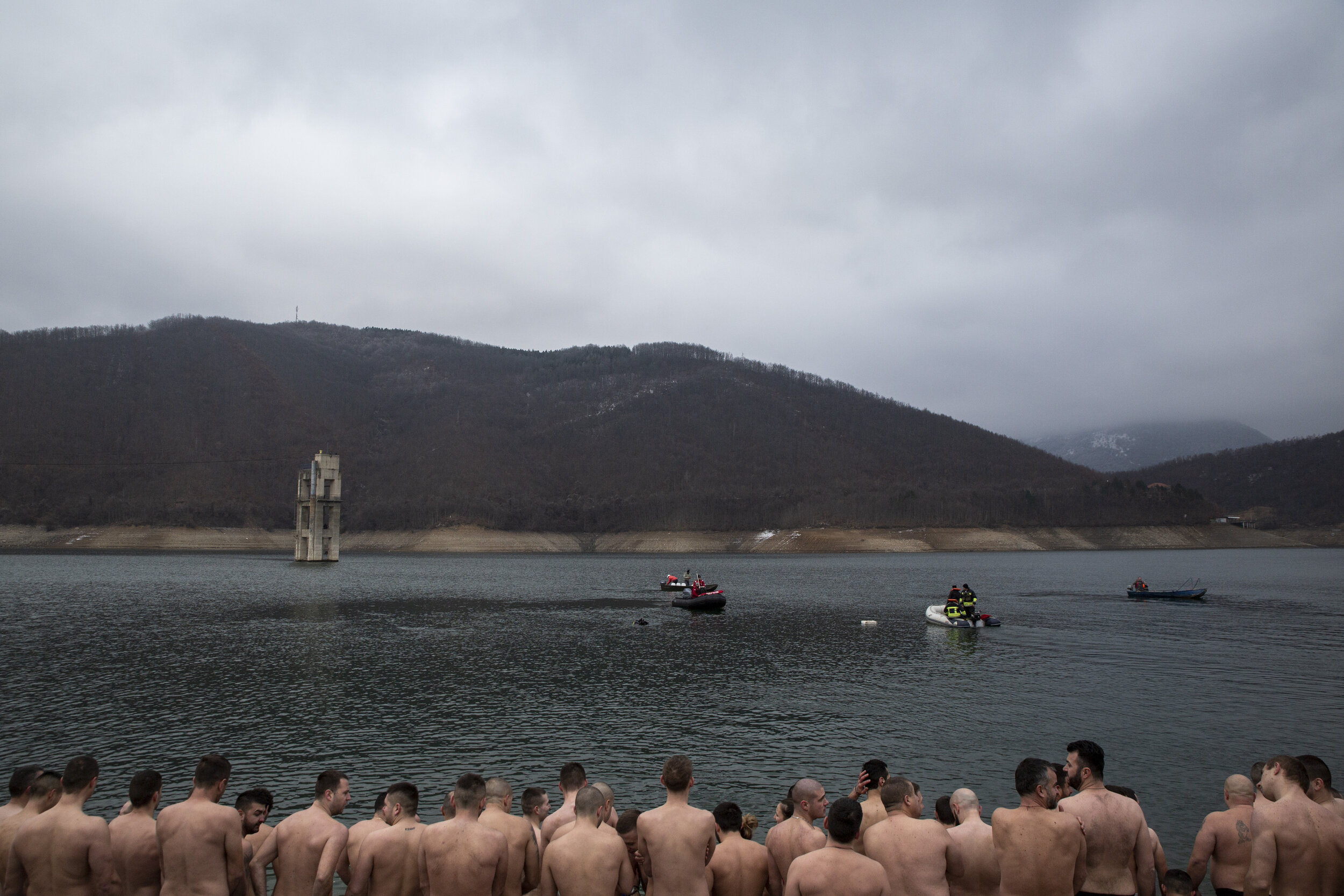  Men from Serb-majority municipalities of North Kosovo gather along the shore of Gazivoda Lake in Zubin Potok to participate in Epiphany cross diving on Jan. 19, 2020. Each year on the day of Christ’s baptism, Orthodox priests throw a gold cross into