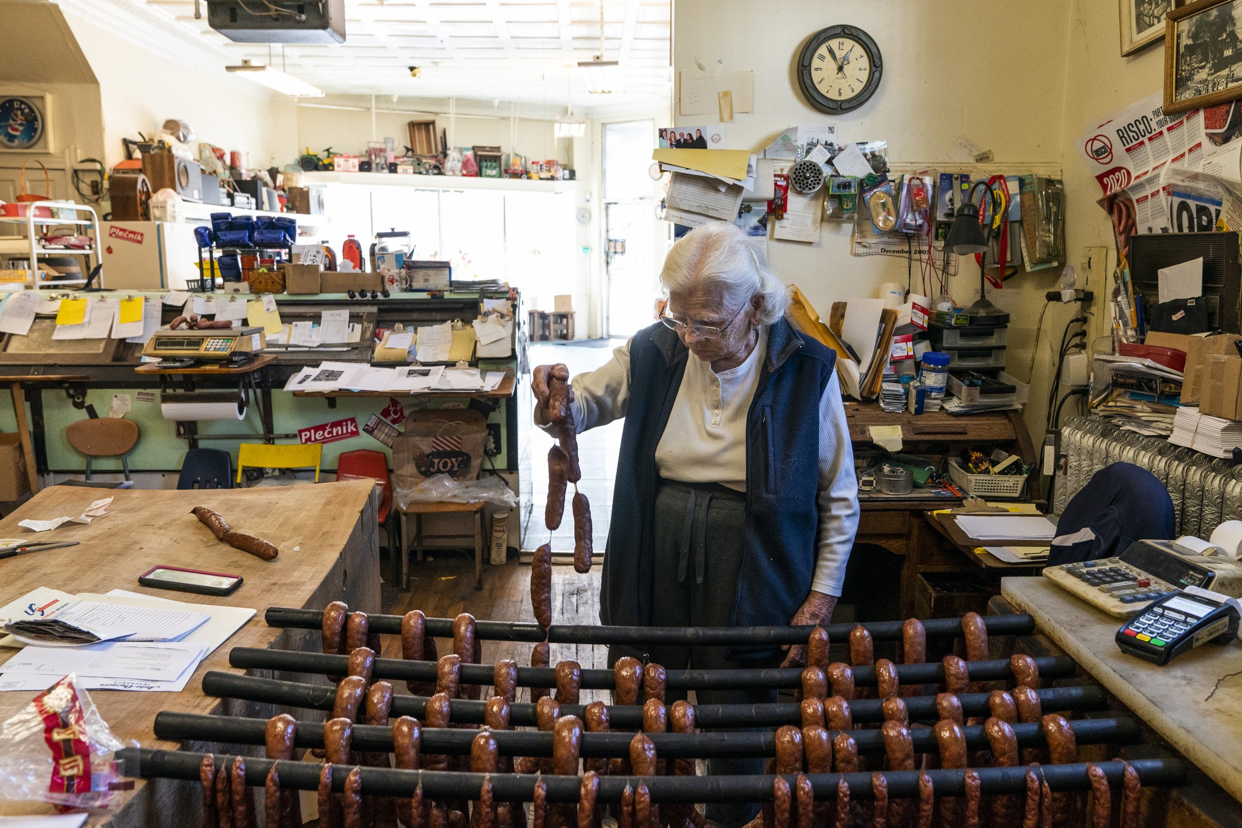  Ancka, a Slovenian customer whose been shopping at Azman &amp; Sons Market in Cleveland, Ohio since 1961, walks behind the counter to handpick her sausage links on Oct. 15, 2020.  