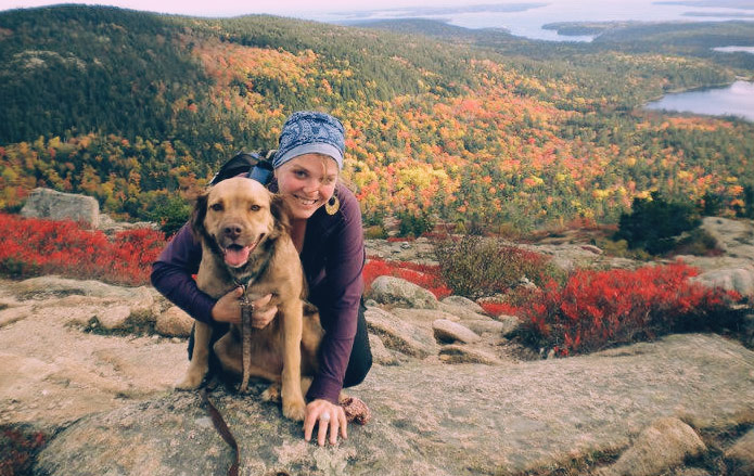 Chelsea and her pup checking out the changing leaves in Maine