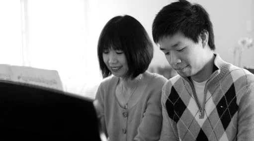 Michelle Chen Kuo and Christopher Kuo of Two Piano Journey practicing piano.