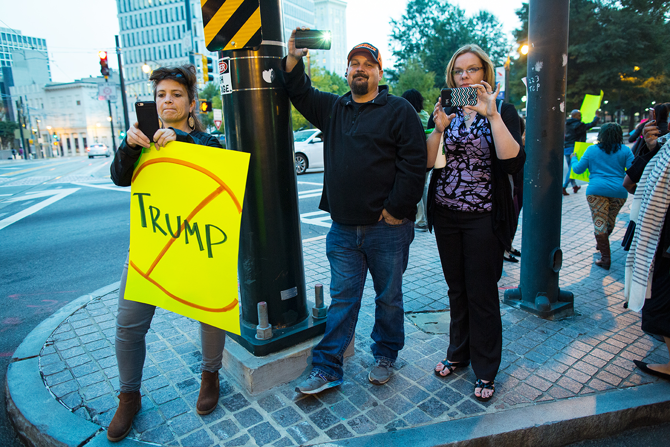 Anti-Trump protester and bystanders photograph march held during the Facing Race 2016 conference against president-elect Donald Trump, who gave voice to  bigotry  and  encouraged violence  during his campaign. Atlanta, GA, 10 November   