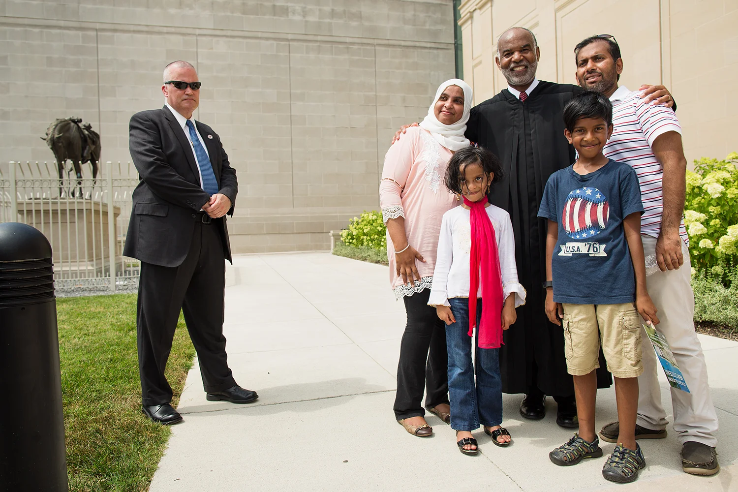 Family poses with the Honorable Roger L. Gregory, Chief Judge, U.S. Court of Appeals for the Fourth Circuit, after Fourth of July citizenship naturalization ceremony at the Virginia Historical Society, Richmond, VA 2017