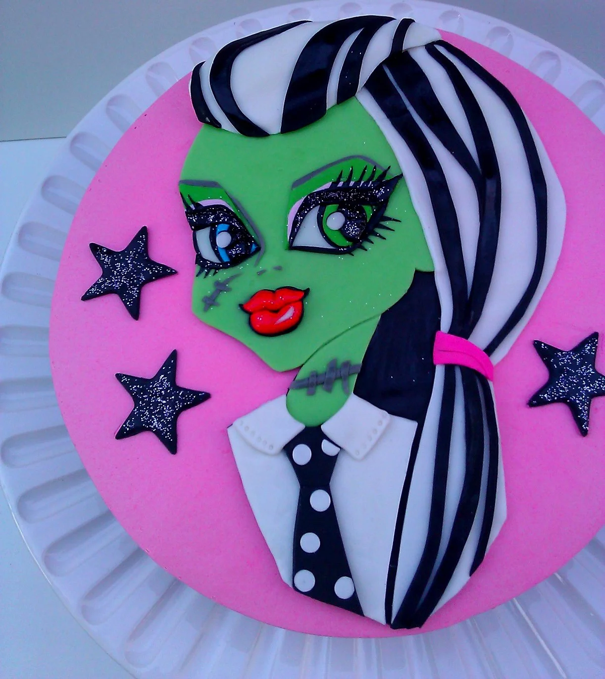 Frankie Stein herself of fondant on top of another "Monster High" themed party cake
