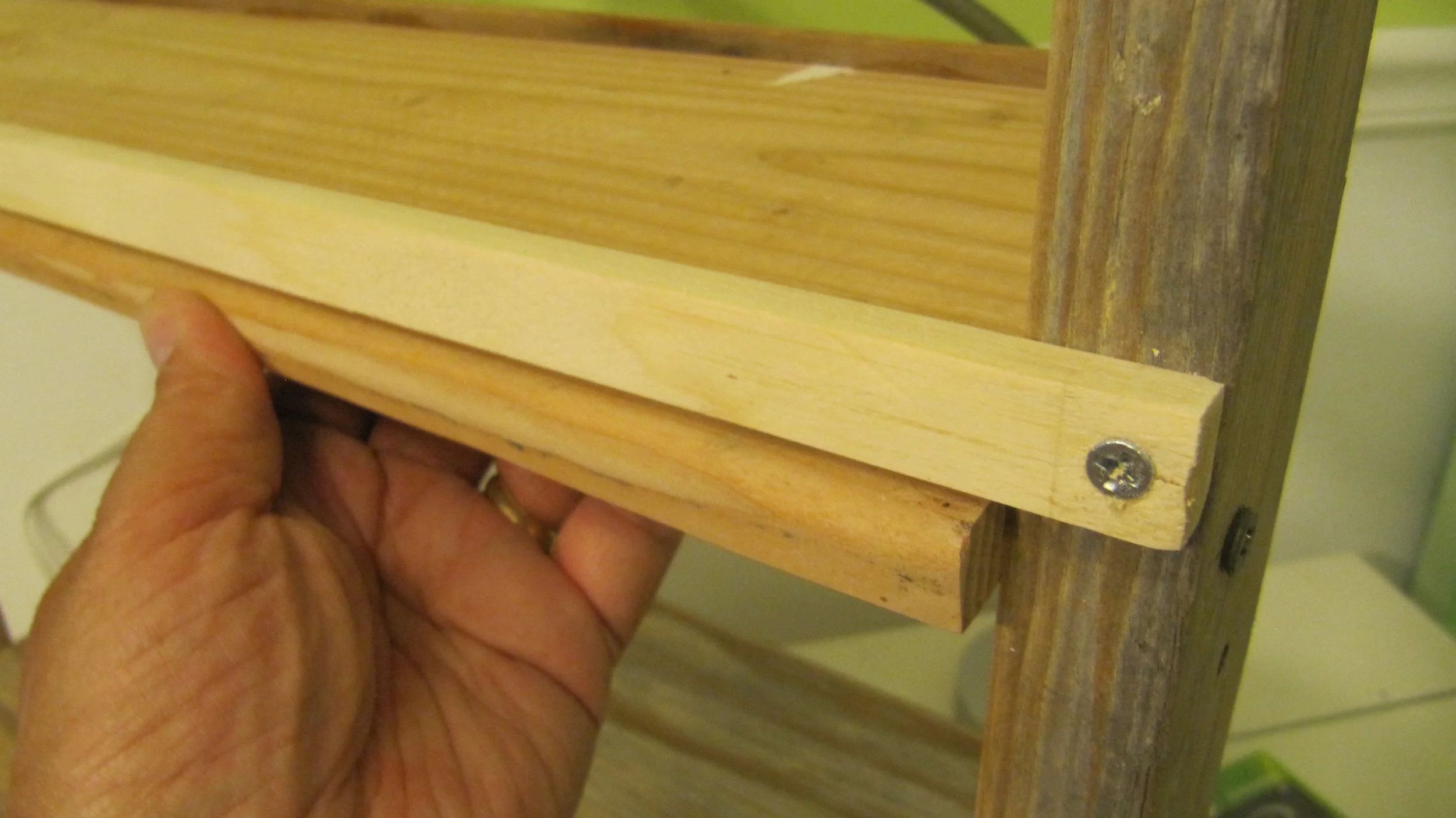 A wooden strip across the back also keeps the shelf in place and keeps things from falling off.