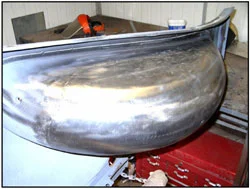 A Cadillac spare wheel carrier is completely replaced and filed finished at one of the workstations.