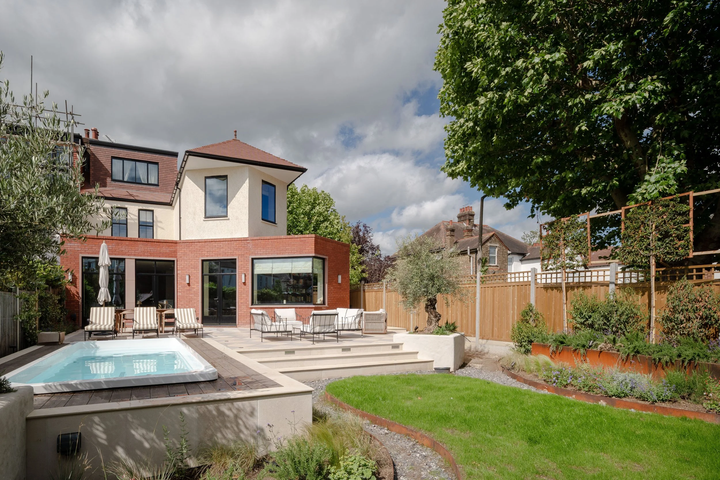  The transformation extended beyond the house itself, with a complete landscaping scheme designed to complement the architecture. The grounds feature a striking checkerboard stone patio, a luxury spa pool, and extensive soft landscaping with carefull